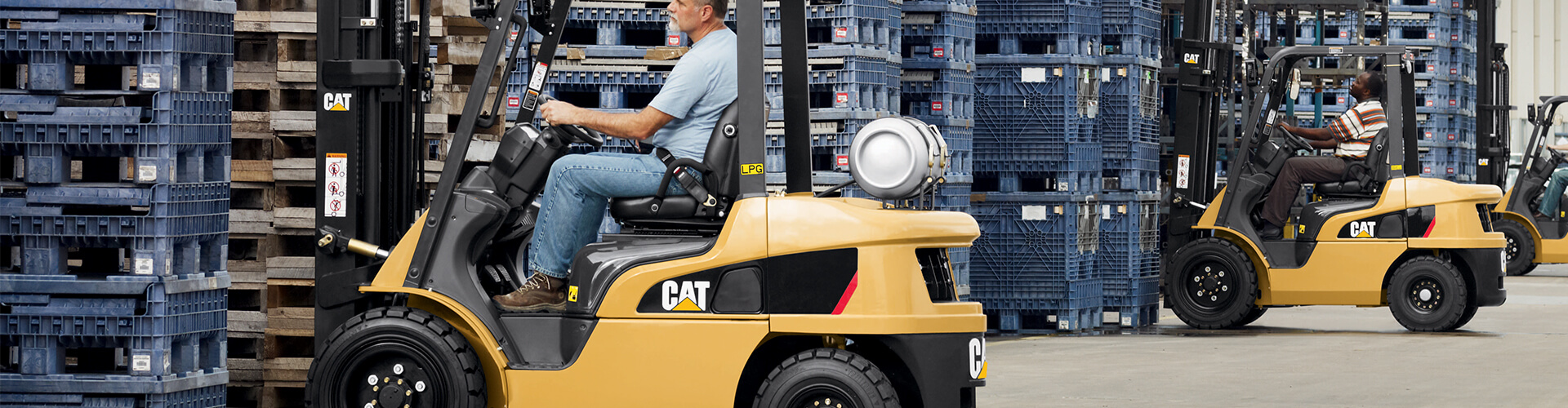 Cat Forklift drivers packing plastic pallets of products in a warehouse